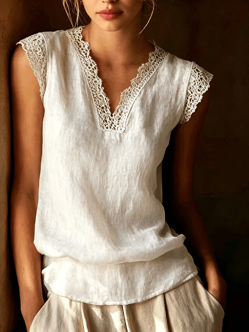 White lace-trimmed top worn by a person against a dark background