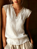White lace-trimmed top worn by a person against a dark background