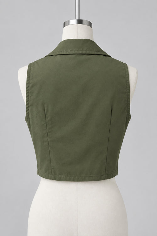 An olive green sleeveless collared vest displayed on a white dress form mannequin, photographed in an indoor room with windows, curtains, and a plant visible in the background.