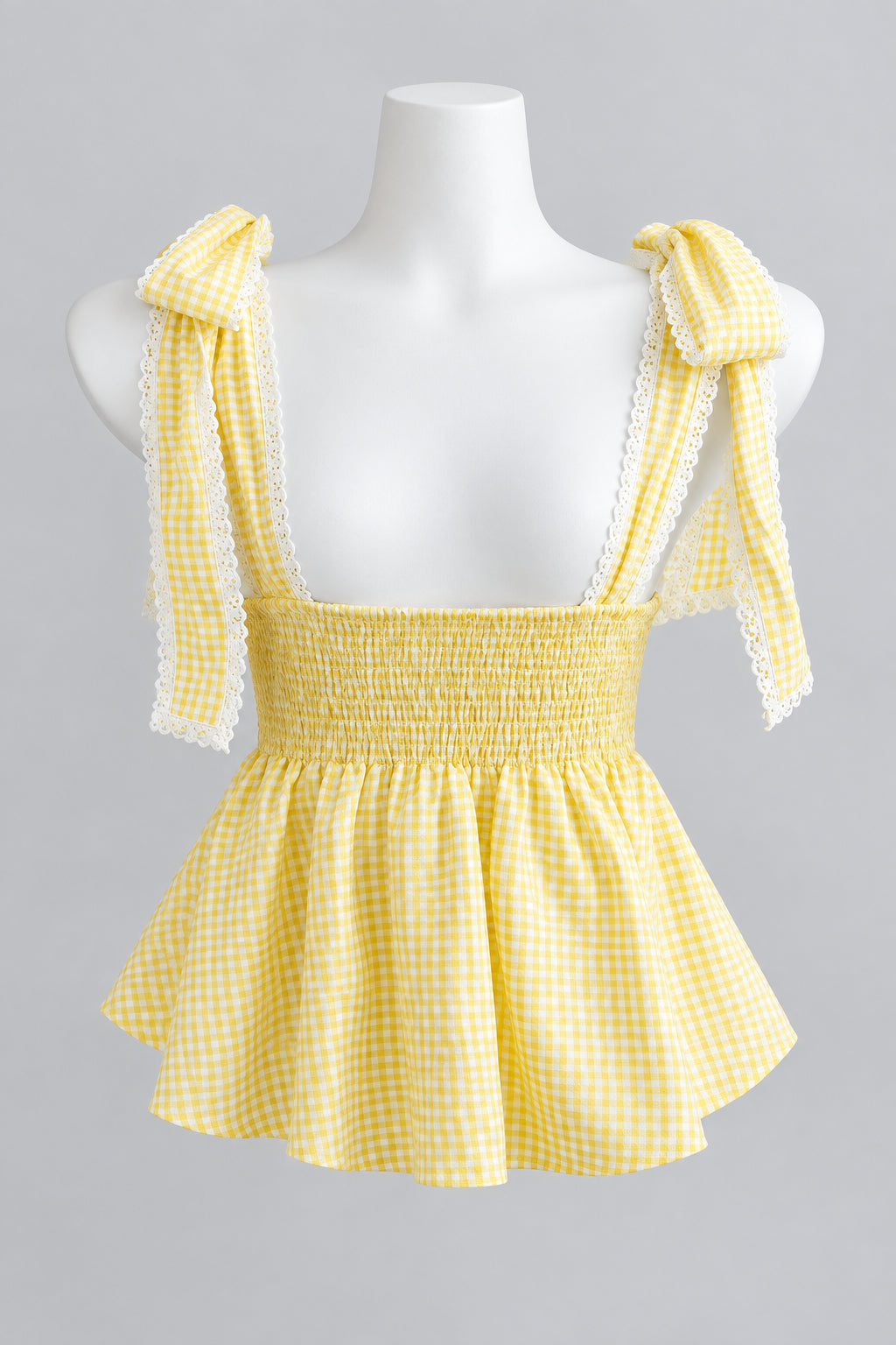 Yellow and white gingham tie-shoulder ruffled top displayed on a white mannequin torso.
